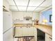 This galley kitchen features white cabinets and appliances, plus a breakfast bar at 14950 Gulf Blvd # 905, Madeira Beach, FL 33708
