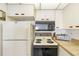 Kitchen view with white refrigerator, microwave, stove, oven, and countertops at 14950 Gulf Blvd # 905, Madeira Beach, FL 33708