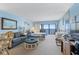 Living room featuring a bedroom view, light blue walls, balcony slider, and comfortable seating at 14950 Gulf Blvd # 905, Madeira Beach, FL 33708