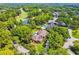 An aerial view of a home with a pool, golf course in the distance, and lush green landscaping at 16502 Millan De Avila, Tampa, FL 33613
