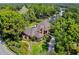 An aerial view showcasing a home with a pool, golf course in the distance, and lush green landscaping at 16502 Millan De Avila, Tampa, FL 33613