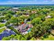 An aerial view of a private estate surrounded by lush greenery, a pool, and lake in the distance at 16502 Millan De Avila, Tampa, FL 33613