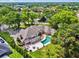 An aerial view of a grand home featuring a backyard pool, patio, and lush green landscaping at 16502 Millan De Avila, Tampa, FL 33613