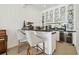Stylish bar area with custom cabinetry, a wine refrigerator, and seating for two at 16502 Millan De Avila, Tampa, FL 33613