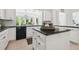 Bright kitchen features black countertops, white cabinetry, an island, and a view to the backyard at 16502 Millan De Avila, Tampa, FL 33613