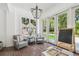 Sunroom features a vintage chandelier, brick floors, and a wall of windows overlooking the pool and backyard at 16502 Millan De Avila, Tampa, FL 33613