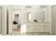 Elegant bathroom with double vanity, white cabinetry, and a view into the bedroom at 16962 Warm Hand Ct, Land O Lakes, FL 34638