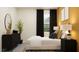 Comfortable bedroom features black-out curtains, modern lamps, a dresser, and a decorative plant at 16962 Warm Hand Ct, Land O Lakes, FL 34638