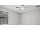 Bright, neutral bedroom with light gray walls, carpet, and ceiling fan at 17404 Nokota Ave, Hudson, FL 34667