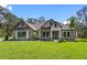 Beautiful stone-accented home with lush lawn and meticulous landscaping under a blue sky at 17404 Nokota Ave, Hudson, FL 34667