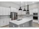 Bright kitchen with white cabinets, a large island, stainless steel appliances, and stylish pendant lights at 17404 Nokota Ave, Hudson, FL 34667