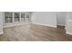 Spacious living room featuring light hardwood floors and three large bright windows at 17404 Nokota Ave, Hudson, FL 34667