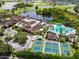 Stunning aerial view showcasing the community's pool, tennis courts, lush landscaping, and surrounding lakes at 1904 Canterbury Ln # 18, Sun City Center, FL 33573
