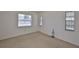 A bright bedroom features neutral carpet and walls, plus three windows at 1904 Canterbury Ln # 18, Sun City Center, FL 33573
