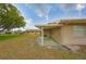 Exterior view of the home featuring a grassy area and access to the screened-in patio at 1904 Canterbury Ln # 18, Sun City Center, FL 33573