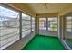 Enclosed Florida room with bright green carpet and multiple windows overlooking the backyard at 1904 Canterbury Ln # 18, Sun City Center, FL 33573