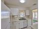 Clean kitchen with white appliances, ample counter space, and a view to the outdoor patio at 1904 Canterbury Ln # 18, Sun City Center, FL 33573