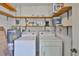 Laundry room with open shelving, a washer, dryer, and water heater at 1904 Canterbury Ln # 18, Sun City Center, FL 33573