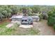 Aerial view of the home, highlighting the roof, solar panels, back deck, and expansive yard at 27315 Popiel Rd, Brooksville, FL 34602