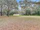 This large backyard features mature trees, offering ample shade and a serene environment at 27315 Popiel Rd, Brooksville, FL 34602