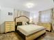 Elegant bedroom featuring a tufted headboard, classic dressers, and plenty of natural light at 27315 Popiel Rd, Brooksville, FL 34602