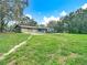 Expansive lawn surrounds this home with an attached garage, back deck, and outdoor features at 27315 Popiel Rd, Brooksville, FL 34602