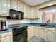 Bright kitchen featuring updated appliances, white cabinetry, and a cozy breakfast nook at 27315 Popiel Rd, Brooksville, FL 34602
