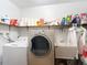 Functional laundry room with washer, dryer, utility sink, and ample shelving for storage and cleaning supplies at 27315 Popiel Rd, Brooksville, FL 34602