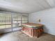 Enclosed sun room featuring a built-in hot tub, windows, and a comfortable space for relaxation and entertainment at 27315 Popiel Rd, Brooksville, FL 34602