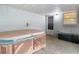 Enclosed sun room featuring a built-in hot tub, windows, and a comfortable space for relaxation and entertainment at 27315 Popiel Rd, Brooksville, FL 34602