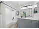 Updated bathroom with a grey vanity, black hardware, and tub with shower at 3004 Conifer Dr, Largo, FL 33771