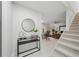 Open-concept entryway boasts a modern black console table, mirror, and staircase leading to the upper level at 3004 Conifer Dr, Largo, FL 33771