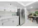 Modern kitchen with stainless steel refrigerator and white cabinets open to the dining room at 3004 Conifer Dr, Largo, FL 33771