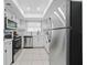 Well-lit kitchen showcasing white cabinets, stainless steel appliances, tile floors, and modern fixtures at 3004 Conifer Dr, Largo, FL 33771