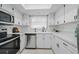 Bright kitchen features white cabinets, stainless steel appliances, tile backsplash, and large window at 3004 Conifer Dr, Largo, FL 33771
