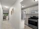 View of a well-lit hallway with tile flooring leading to the living area and a partial view of the kitchen at 3114 59Th S St # 203, Gulfport, FL 33707