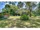 View of the backyard, mature trees, and a screened-in structure at 38839 Miller Ave, Zephyrhills, FL 33542