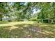 Extensive backyard with lush greenery, mature trees, and outbuildings at 38839 Miller Ave, Zephyrhills, FL 33542