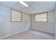 Bedroom featuring wood paneling, carpet, ceiling tiles, and two windows at 38839 Miller Ave, Zephyrhills, FL 33542