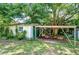 Exterior view of garage doors and surrounding yard with mature trees at 38839 Miller Ave, Zephyrhills, FL 33542