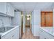 Galley kitchen featuring white cabinets, marble countertops and stainless steel refrigerator at 38839 Miller Ave, Zephyrhills, FL 33542