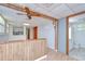 Cozy living room with wood walls, ceiling fan and direct view to the kitchen and bathroom at 38839 Miller Ave, Zephyrhills, FL 33542