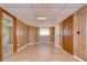 Spacious living room featuring wood paneling, window and ceiling tiles at 38839 Miller Ave, Zephyrhills, FL 33542