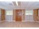 Spacious living room with wood walls, bright windows, and modern wood-look flooring at 38839 Miller Ave, Zephyrhills, FL 33542