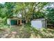 View of the property's detached garage, a storage shed, and surrounding trees at 38839 Miller Ave, Zephyrhills, FL 33542