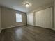Bedroom with wood-look flooring, natural light, and a double-door closet at 404 Water St, Plant City, FL 33563