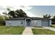 Charming single-story home with gray exterior, well-maintained lawn, and an attached garage at 404 Water St, Plant City, FL 33563