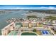 Panoramic aerial of condo complex featuring water views, tennis courts, parking, and beautifully kept landscaping at 4725 Cove Circle # 908, St Petersburg, FL 33708