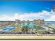 Panoramic aerial view of the building complex with a lake, tennis courts, and lush landscaping under a blue sky at 4725 Cove Circle # 908, St Petersburg, FL 33708