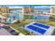 An aerial shot showcasing a large pool, tennis courts, lush landscaping, parking, and surrounding water views at 4725 Cove Circle # 908, St Petersburg, FL 33708